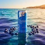 Cannette Red Bull Summer Edition Juneberry flottant sur la mer avec reflets du soleil et baies juneberry autour du produit.